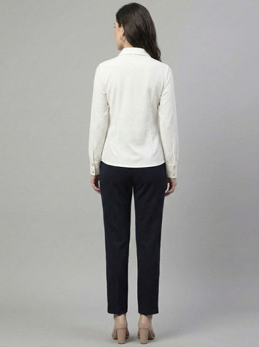 Woman wearing a white shirt and black pants on a gray background